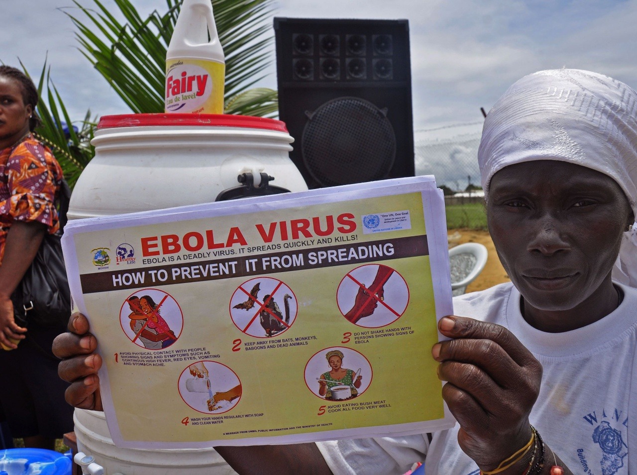 Žena z Libérie ukazuje plagát s pokynmi, ako zabrániť šíreniu eboly. 